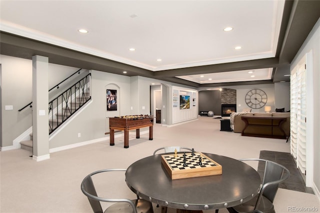 dining space featuring a fireplace, a raised ceiling, and carpet