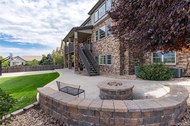 view of patio with an outdoor fire pit and central air condition unit