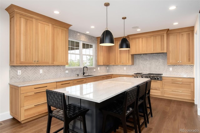 kitchen featuring pendant lighting, sink, dark wood-type flooring, a center island, and stainless steel gas stovetop