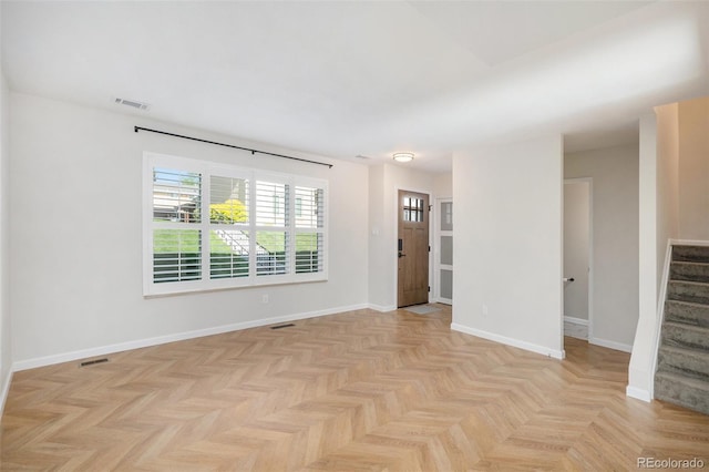empty room featuring stairs and baseboards
