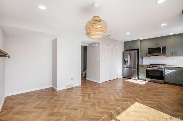 kitchen featuring appliances with stainless steel finishes, recessed lighting, light countertops, decorative light fixtures, and baseboards