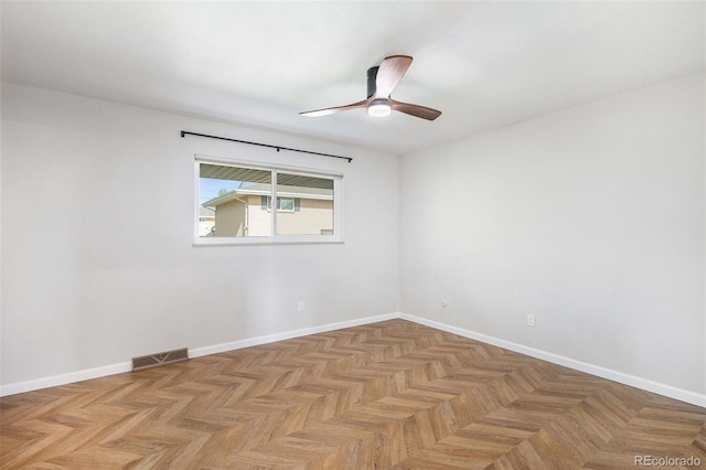 unfurnished room with ceiling fan and baseboards