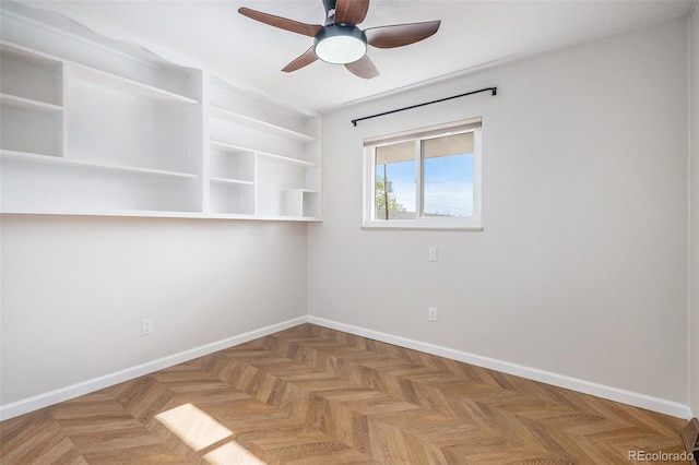 empty room featuring ceiling fan and baseboards