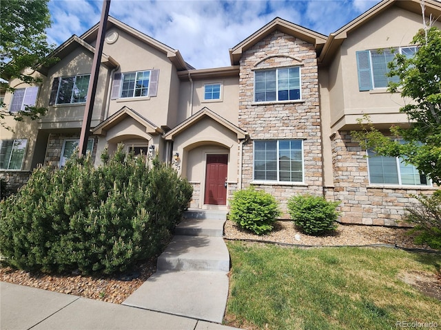 view of property featuring stucco siding and stone siding