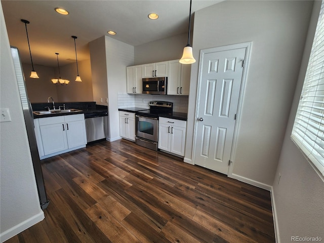 kitchen featuring tasteful backsplash, a sink, dark countertops, stainless steel appliances, and white cabinets