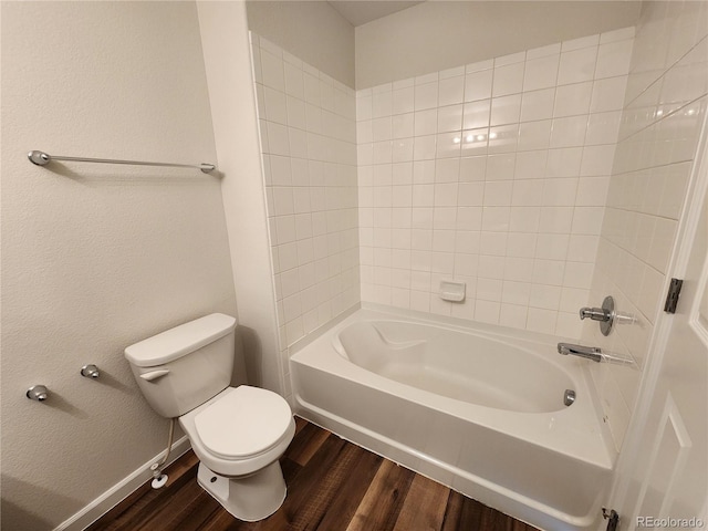 bathroom featuring toilet, bathing tub / shower combination, and wood finished floors