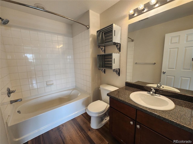 bathroom with toilet, washtub / shower combination, visible vents, and wood finished floors