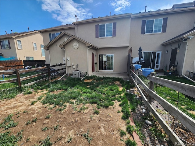 rear view of property featuring stucco siding and a fenced backyard