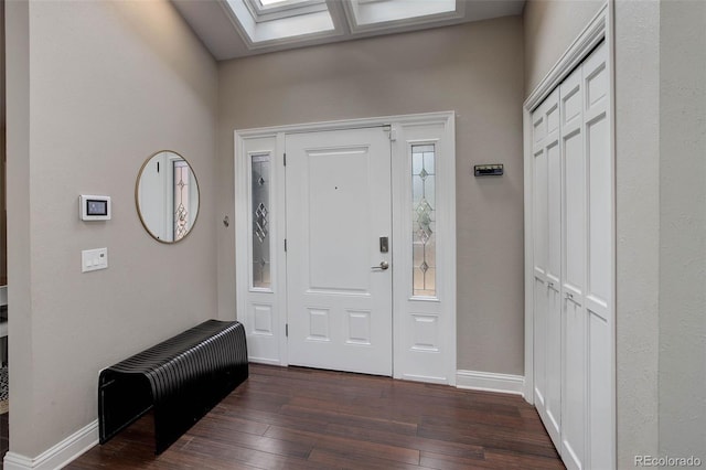 foyer featuring dark wood-style flooring, baseboards, and a skylight