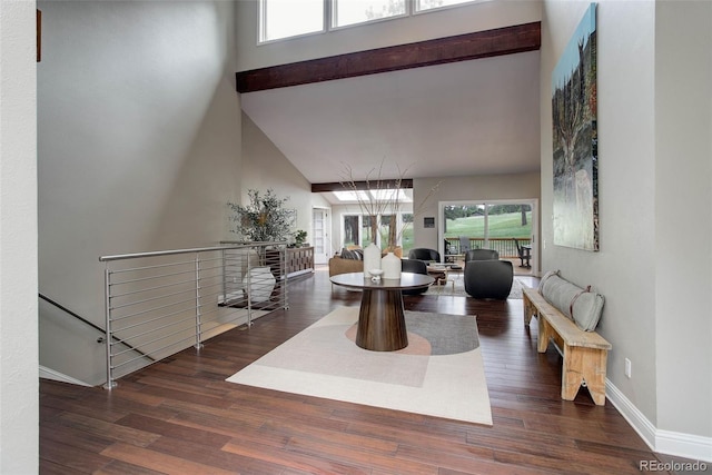 interior space featuring baseboards, a high ceiling, and wood finished floors