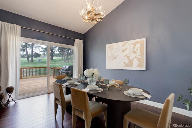 dining room featuring an inviting chandelier, baseboards, wood finished floors, and high vaulted ceiling