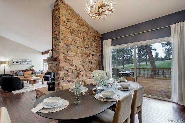 dining area with wood finished floors, a chandelier, and high vaulted ceiling