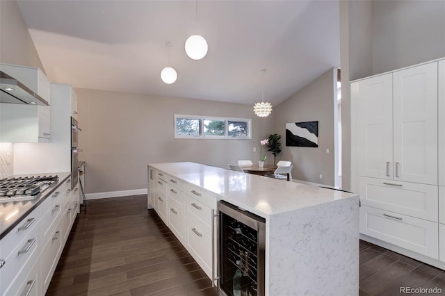kitchen featuring stainless steel gas stovetop, vaulted ceiling, baseboards, wine cooler, and dark wood-type flooring