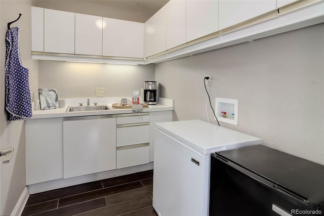 clothes washing area with a sink, washer hookup, dark wood-style flooring, and cabinet space