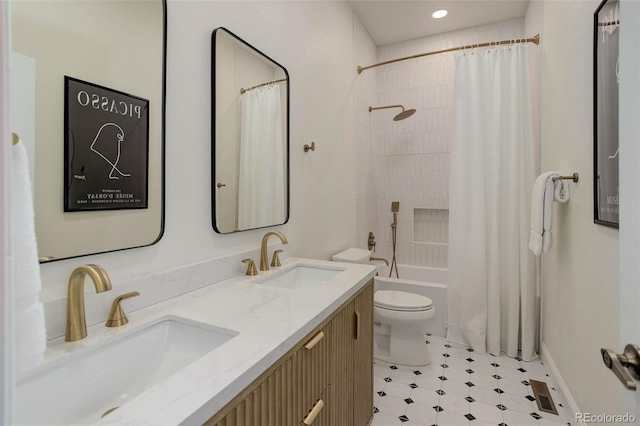 bathroom featuring a sink, shower / bath combo with shower curtain, toilet, and double vanity