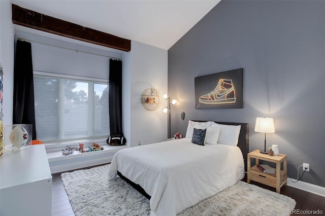 bedroom with baseboards, lofted ceiling, and wood finished floors