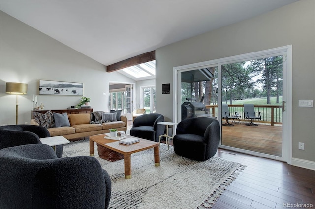 living room with a healthy amount of sunlight, baseboards, vaulted ceiling, and wood finished floors