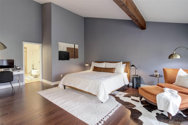 bedroom featuring baseboards, beamed ceiling, wood finished floors, and ensuite bath