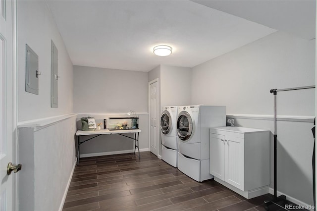laundry area with cabinet space, washer and clothes dryer, electric panel, and dark wood-type flooring