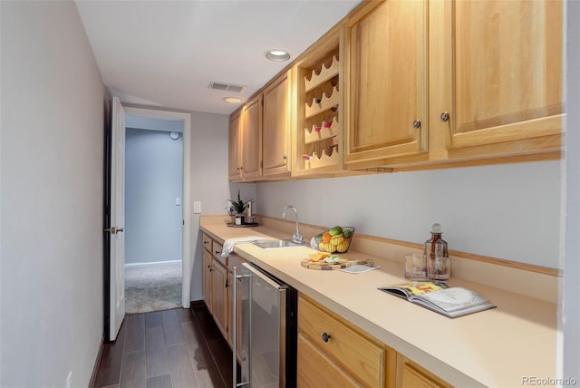 kitchen featuring visible vents, dark wood finished floors, a sink, light countertops, and beverage cooler