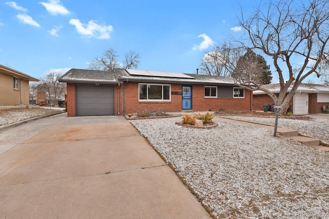 ranch-style home with a garage and solar panels