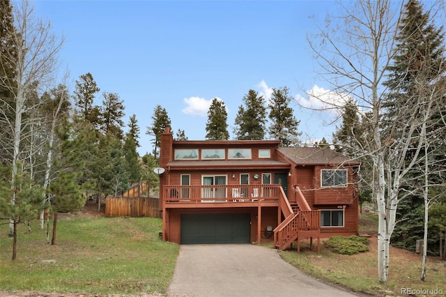 120 Red Rock Ct, Woodland Park, CO 80863 - rustic home with stairs, asphalt driveway, a chimney, a garage, and a front lawn