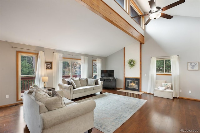 120 Red Rock Ct, Woodland Park, CO 80863 - living area with beamed ceiling, healthy amount of natural light, a ceiling fan, dark wood-style flooring, and a large fireplace