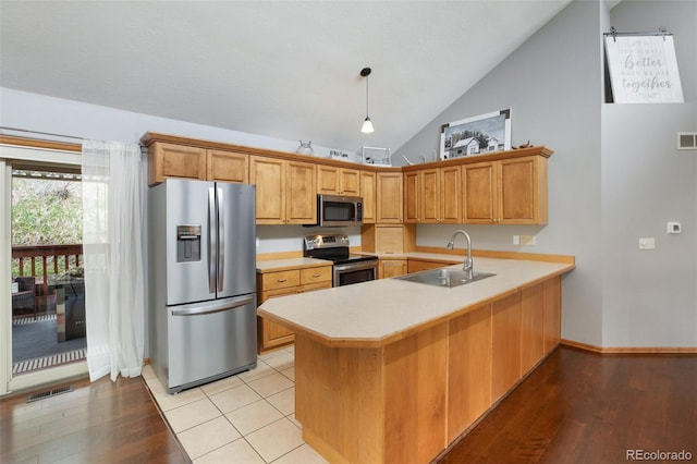 120 Red Rock Ct, Woodland Park, CO 80863 - kitchen featuring appliances with stainless steel finishes, a sink, a peninsula, light countertops, and light wood finished floors