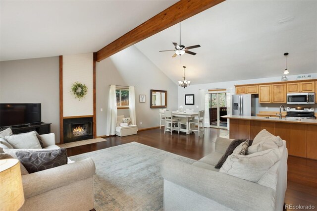 120 Red Rock Ct, Woodland Park, CO 80863 - living area with dark wood-style flooring, a ceiling fan, a chandelier, and a fireplace with flush hearth