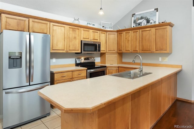 120 Red Rock Ct, Woodland Park, CO 80863 - kitchen with appliances with stainless steel finishes, a sink, a peninsula, light countertops, and vaulted ceiling