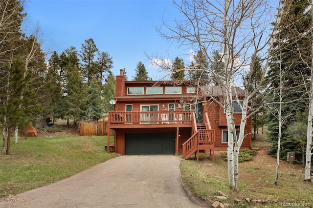 120 Red Rock Ct, Woodland Park, CO 80863 - view of front of property featuring a front lawn, driveway, a chimney, an attached garage, and stairs