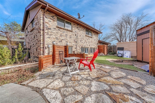 back of property with a storage shed and a patio area