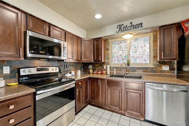 kitchen with tasteful backsplash, appliances with stainless steel finishes, and sink