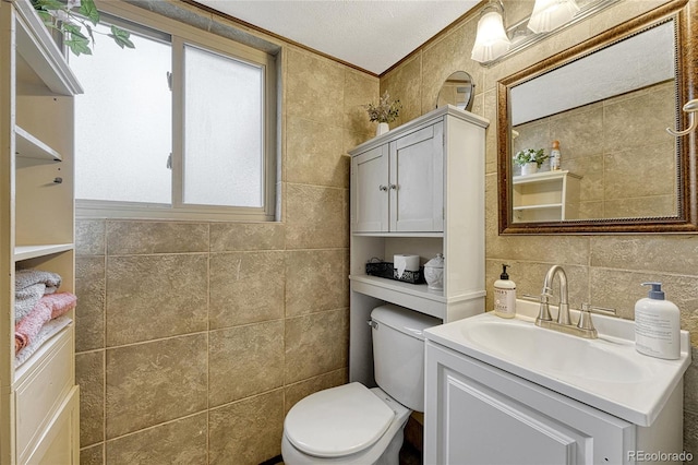 bathroom featuring vanity, tile walls, and toilet