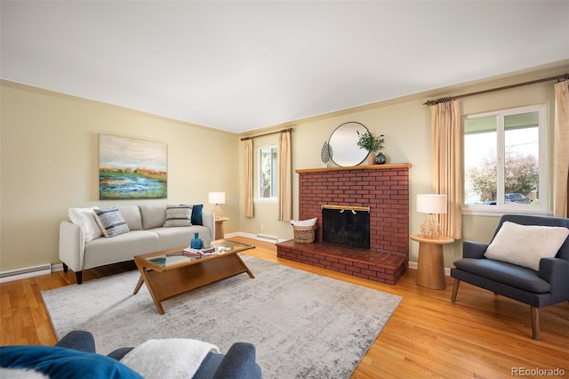 living room featuring a baseboard heating unit, baseboards, a brick fireplace, and light wood-style floors