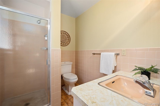 full bathroom with a shower stall, a wainscoted wall, toilet, a sink, and tile walls