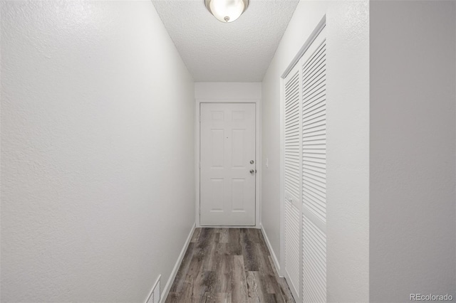 hallway featuring hardwood / wood-style flooring and a textured ceiling