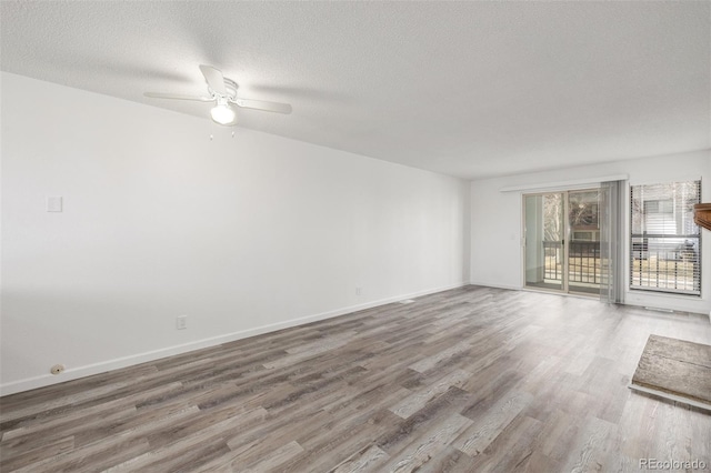 spare room featuring ceiling fan, hardwood / wood-style floors, and a textured ceiling