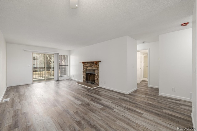 unfurnished living room featuring a fireplace, dark hardwood / wood-style floors, and a textured ceiling