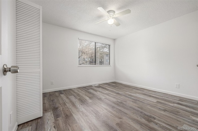 empty room with wood-type flooring, a textured ceiling, and ceiling fan