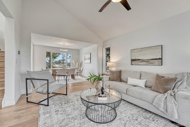 living room featuring ceiling fan, light hardwood / wood-style flooring, and high vaulted ceiling