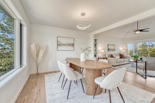 dining room featuring ceiling fan, vaulted ceiling with beams, and light wood-type flooring