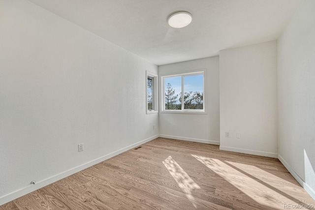 spare room with light hardwood / wood-style flooring