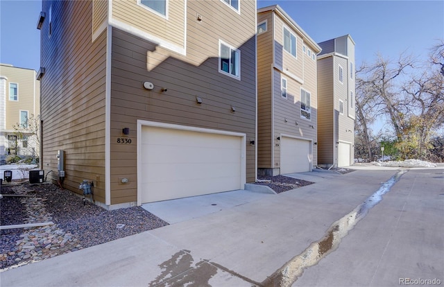 view of property exterior featuring a garage and central AC unit