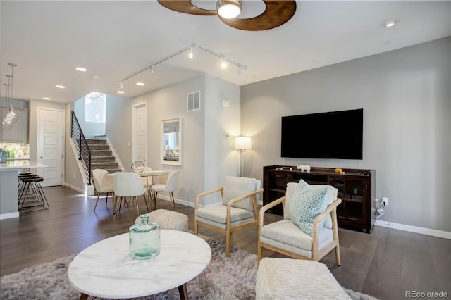 living room featuring ceiling fan and dark wood-type flooring