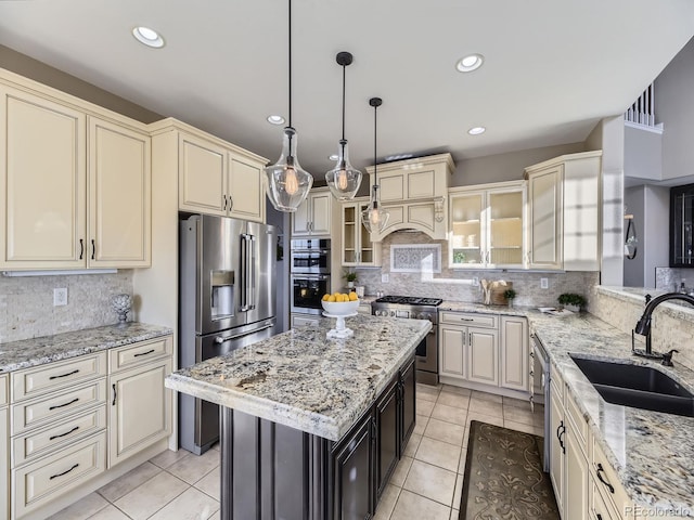 kitchen featuring sink, decorative light fixtures, high quality appliances, a kitchen island, and cream cabinetry