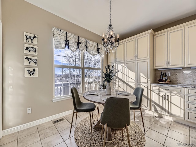 tiled dining room featuring an inviting chandelier