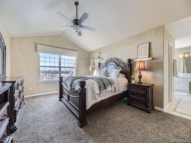 bedroom with ceiling fan, ensuite bathroom, carpet flooring, and vaulted ceiling