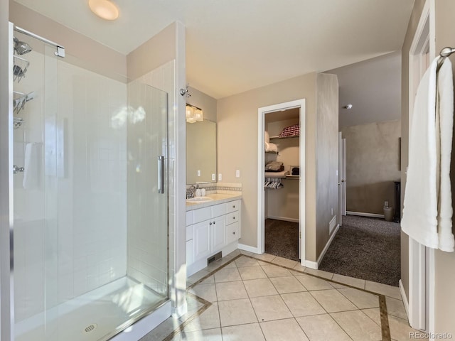 bathroom with an enclosed shower, vanity, and tile patterned flooring