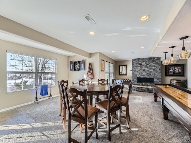 dining space with a stone fireplace and a wealth of natural light